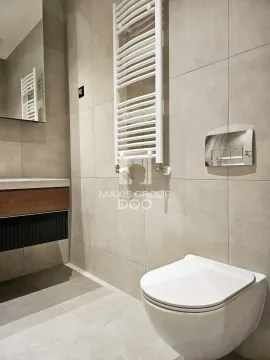 A modern bathroom with a white towel radiator and sanitary ware. - image 16