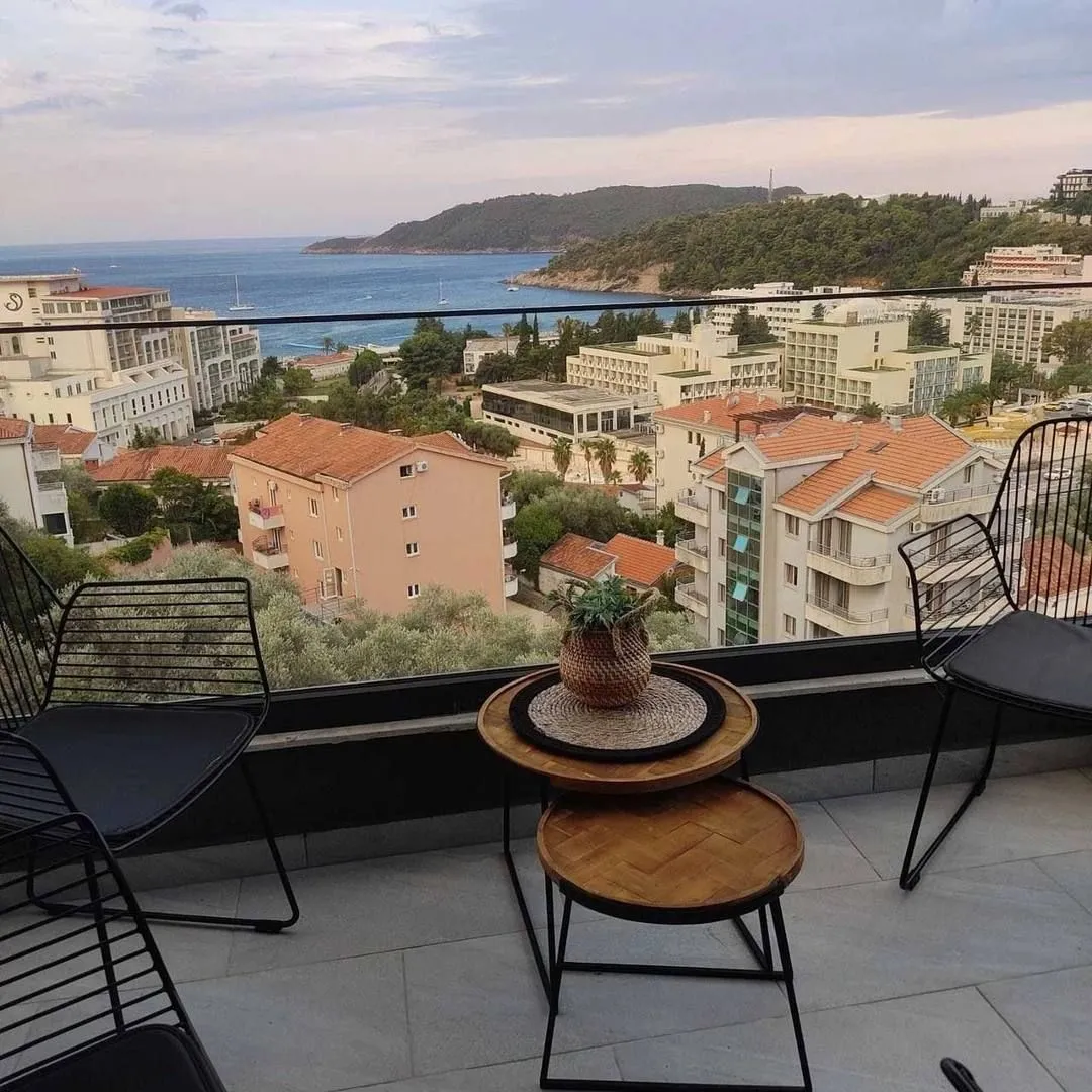 Namještena terasa sa garniturom za sjedenje i pogledom na grad i more.