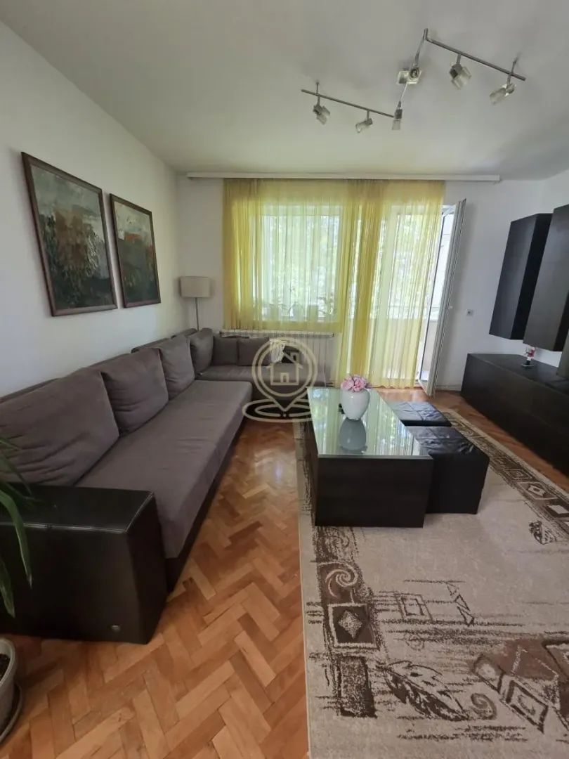 Dnevna soba sa garniturom, stočićem i TV komodom.