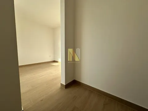Unutrašnjost stana sa drvenim podom i pogledom na drugu prostoriju. - image 18