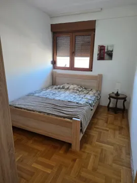 Spavaća soba sa bračnim krevetom, drvenim parketom i prozorom. - image 8