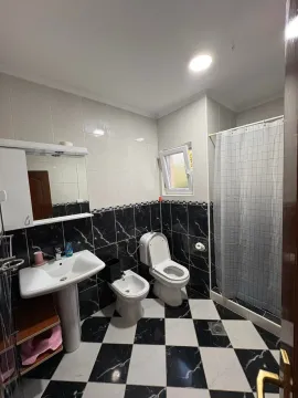 View of the bathroom with black and white tiles, washbasin, bidet, and shower cabin. - image 13