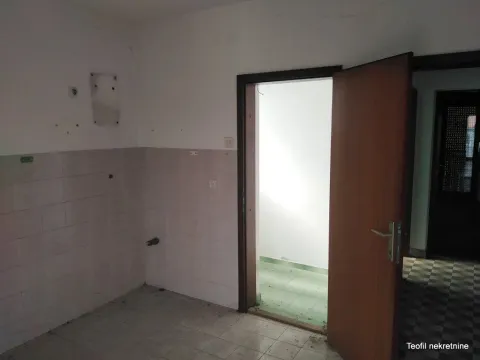 Prazna prostorija sa keramičkim pločicama na zidu i podu, i otvorenim vratima. - image 7