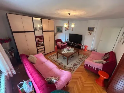 Living room furnished with a wardrobe, seating furniture, and a television. - image 8