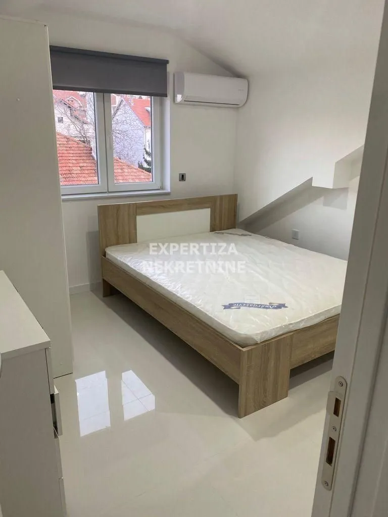 Furnished bedroom with a double bed and a roof window.
