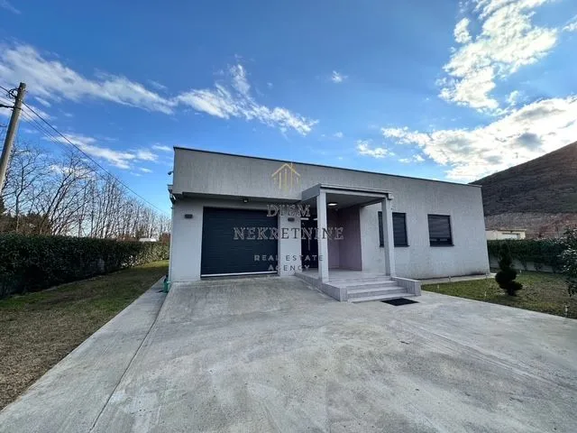 Exterior of a single-story house with a yard and garage.