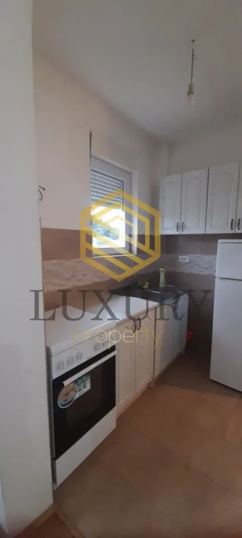 Small kitchen with white cabinets and a stove.