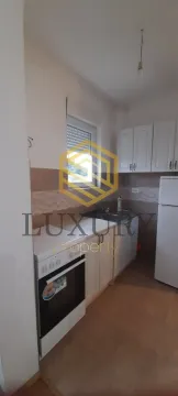 Small kitchen with white cabinets and a stove. - image 3