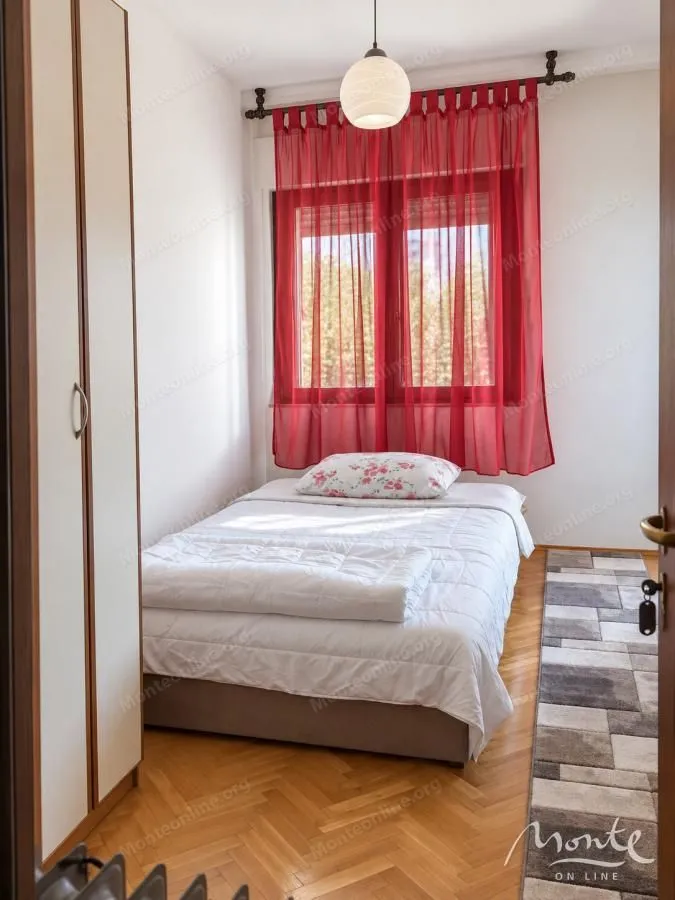 Manja spavaća soba sa krevetom i garderoberom.