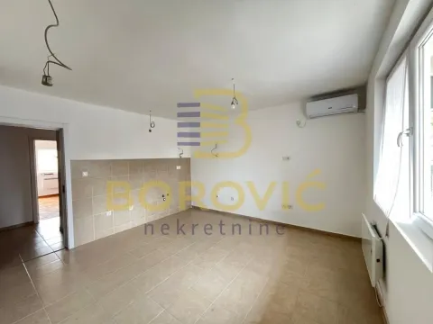 Prazna kuhinja sa pločicama na podu i zidovima i klima uređajem. - image 4