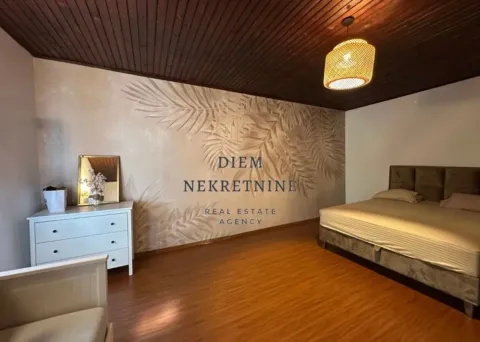 Spacious bedroom with a double bed, wooden ceiling, and a dresser. - image 8