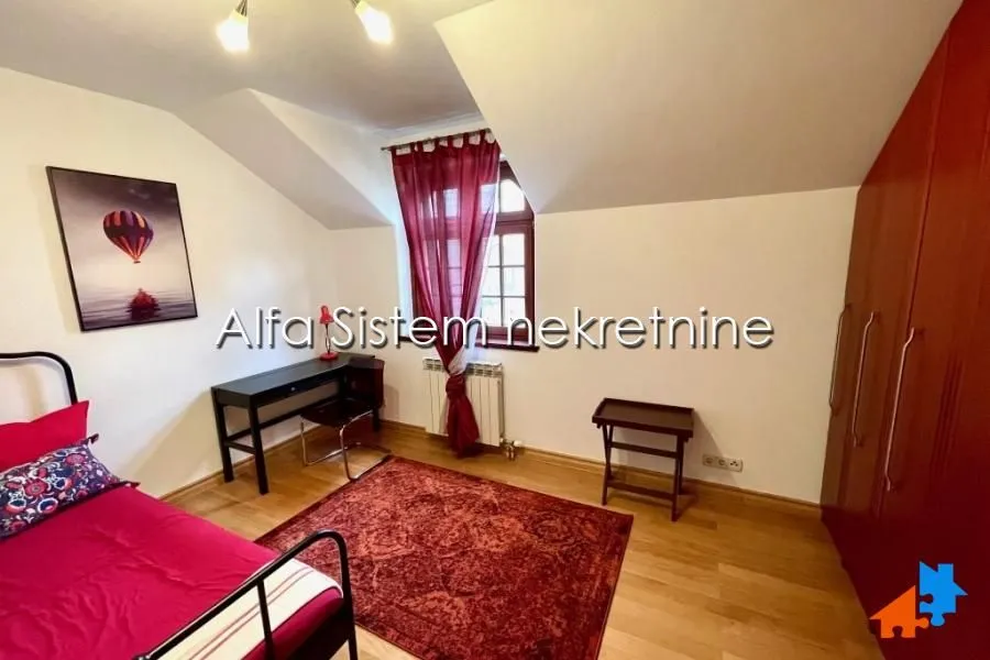 Furnished bedroom with a bed, wardrobe, and desk.