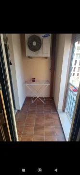 Covered balcony with ceramic tiles and a drying rack. - image 19