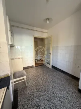 Prazna kuhinja sa pločicama na zidovima i podom od teraca. - image 7