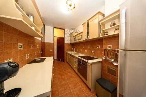 A well-lit kitchen with wooden cabinetry and built-in appliances. - image 6