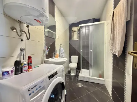 Bathroom equipped with a shower cabin, washbasin, toilet, and washing machine. - image 3
