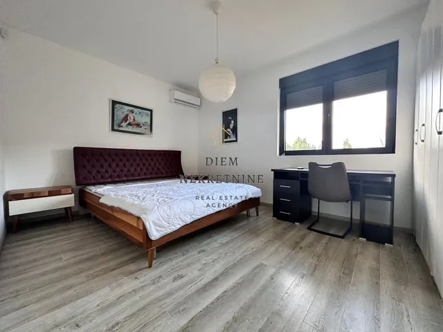 Furnished bedroom with a double bed, desk, and a window.