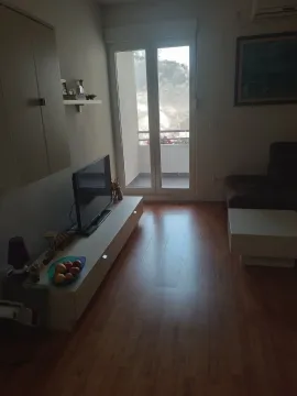 Dnevna soba sa televizorom i izlazom na balkon. - image 2