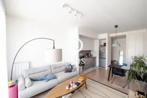 Living room with sofa, dining area, and kitchen in the background. - image 2