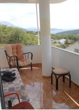 Covered balcony with seating furniture and a view of the surroundings. - image 2