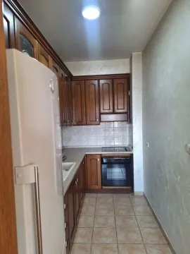 Small kitchen with wooden cabinetry and a built-in oven. - image 6