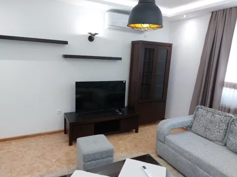 Living room with a sofa set, television, and wooden cabinet. - image 9