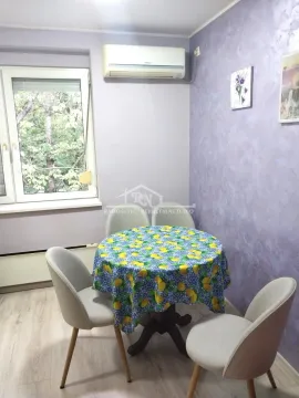 Trpezarijski sto sa četiri stolice u sobi sa prozorom i klima uređajem. - image 5