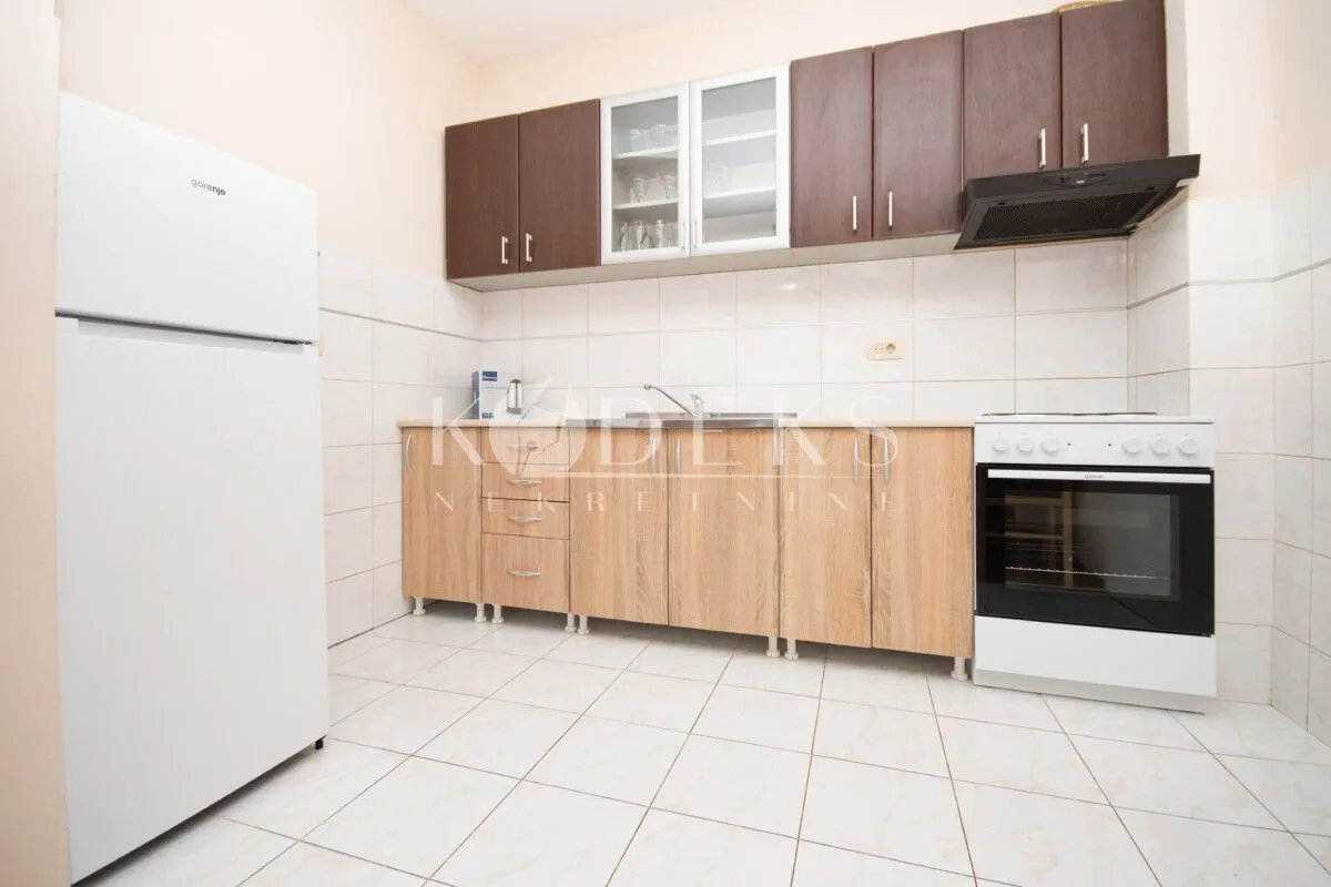 Kitchen with wooden cabinetry, a white refrigerator, and a white stove.