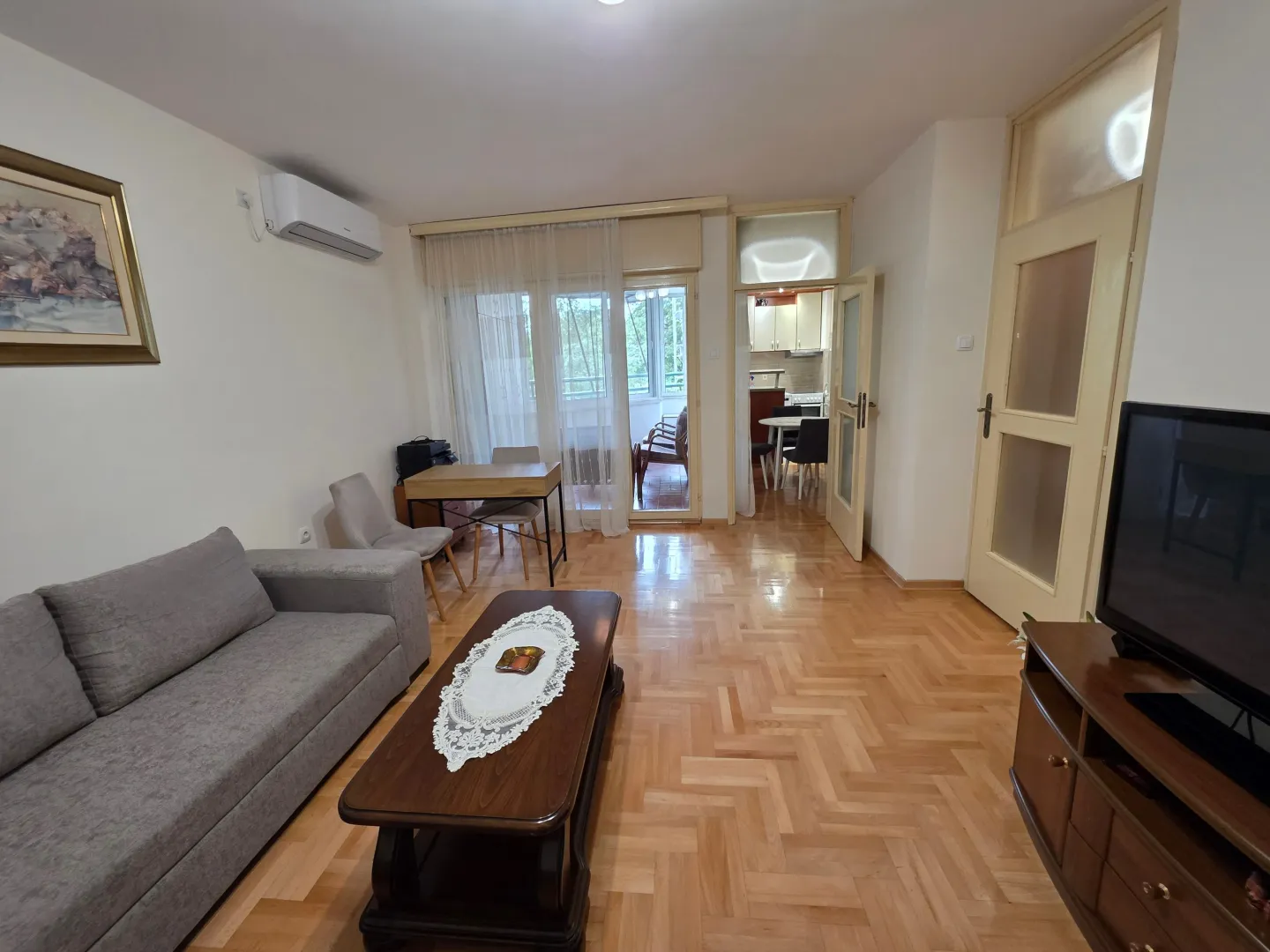 Living room with a sofa, TV, and access to the terrace.