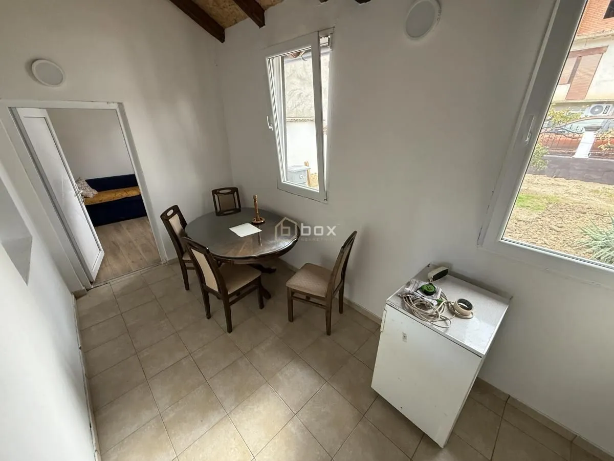 Dining area with a table, chairs, and a view of the yard through the window.