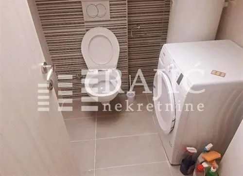 Small bathroom with toilet and washing machine.