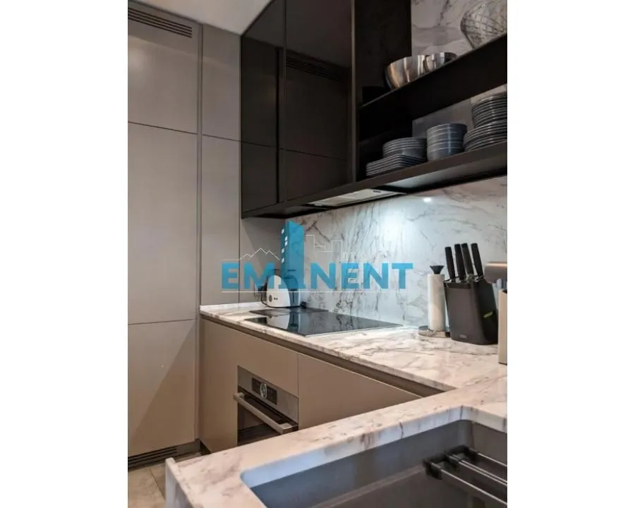 Modern kitchen with marble countertops and built-in appliances.