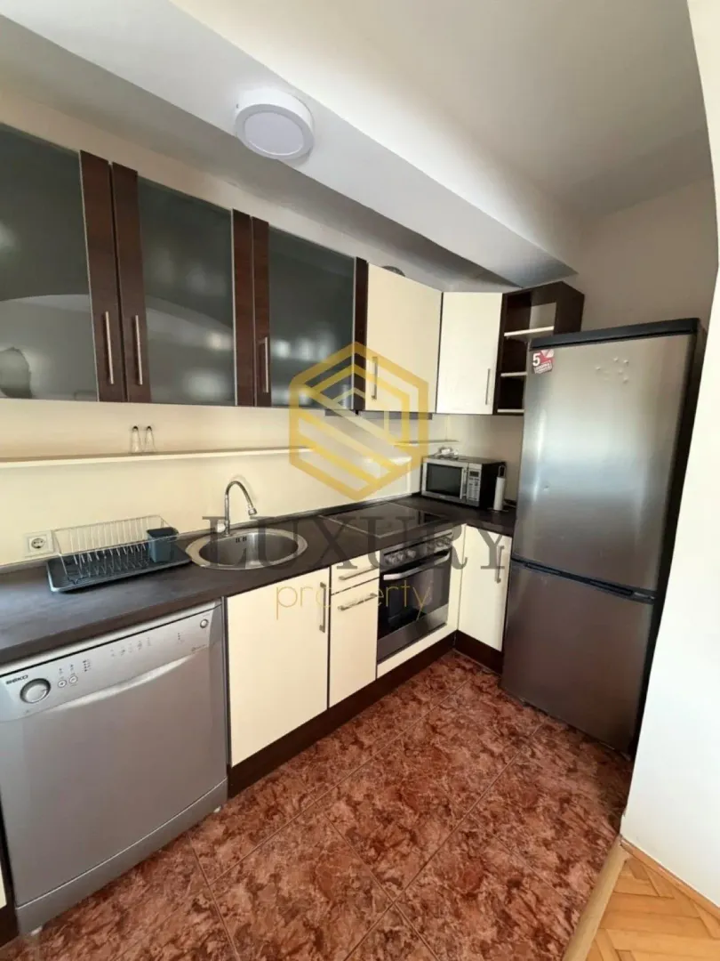 Smaller kitchen with cabinetry and built-in appliances.