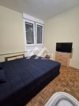 Nameštena spavaća soba sa bračnim krevetom, prozorom i televizorom. - image 7