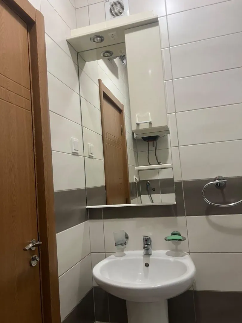 Smaller bathroom with a sink, mirror, and cabinet.