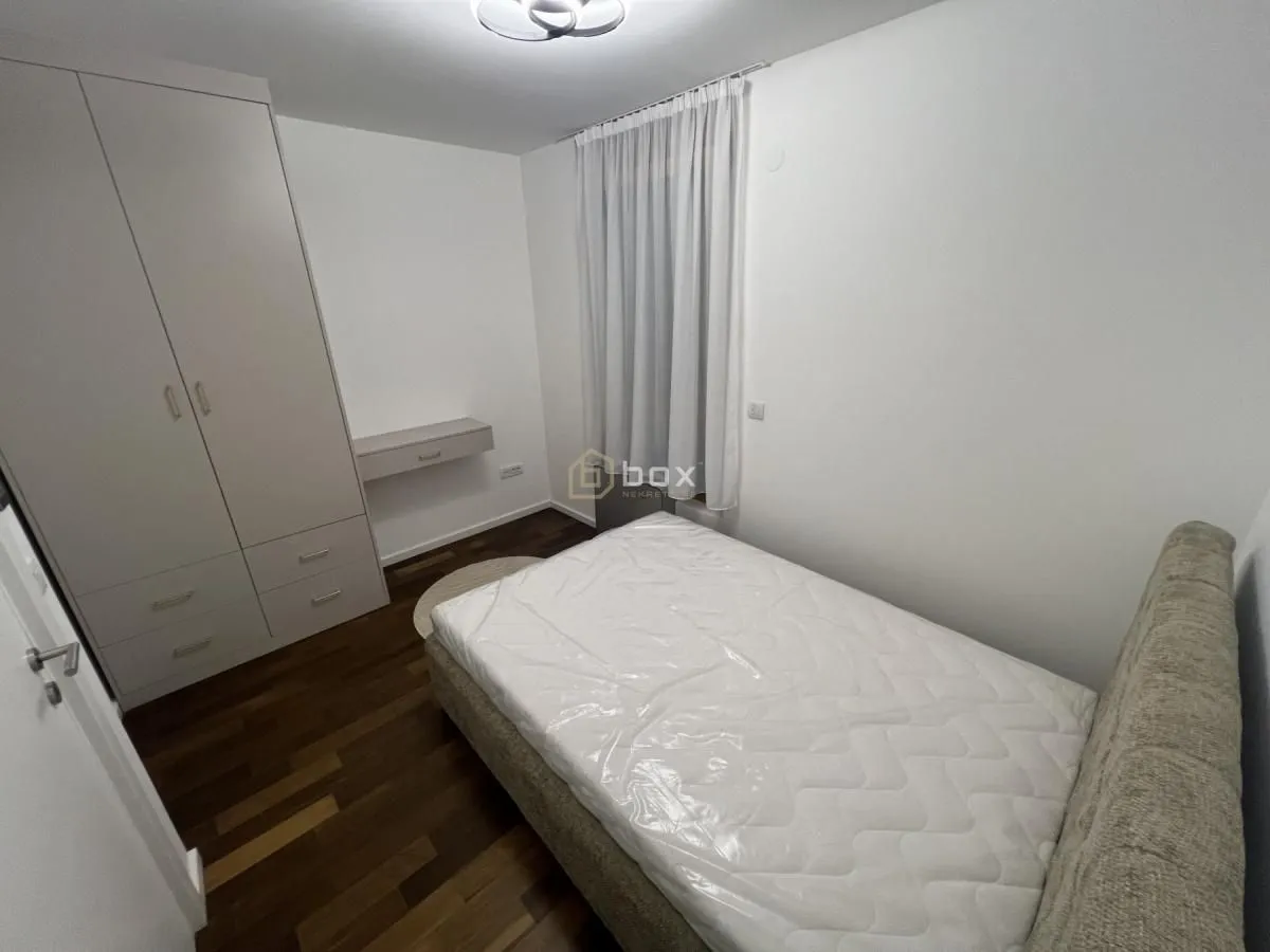 Furnished bedroom with a double bed, wardrobe, and window.