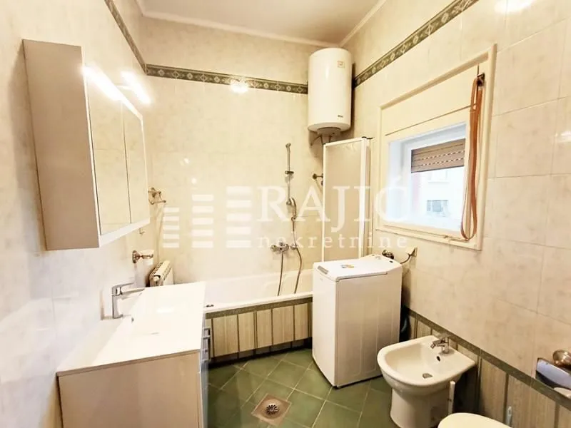 Fully equipped bathroom with a bathtub and washing machine.