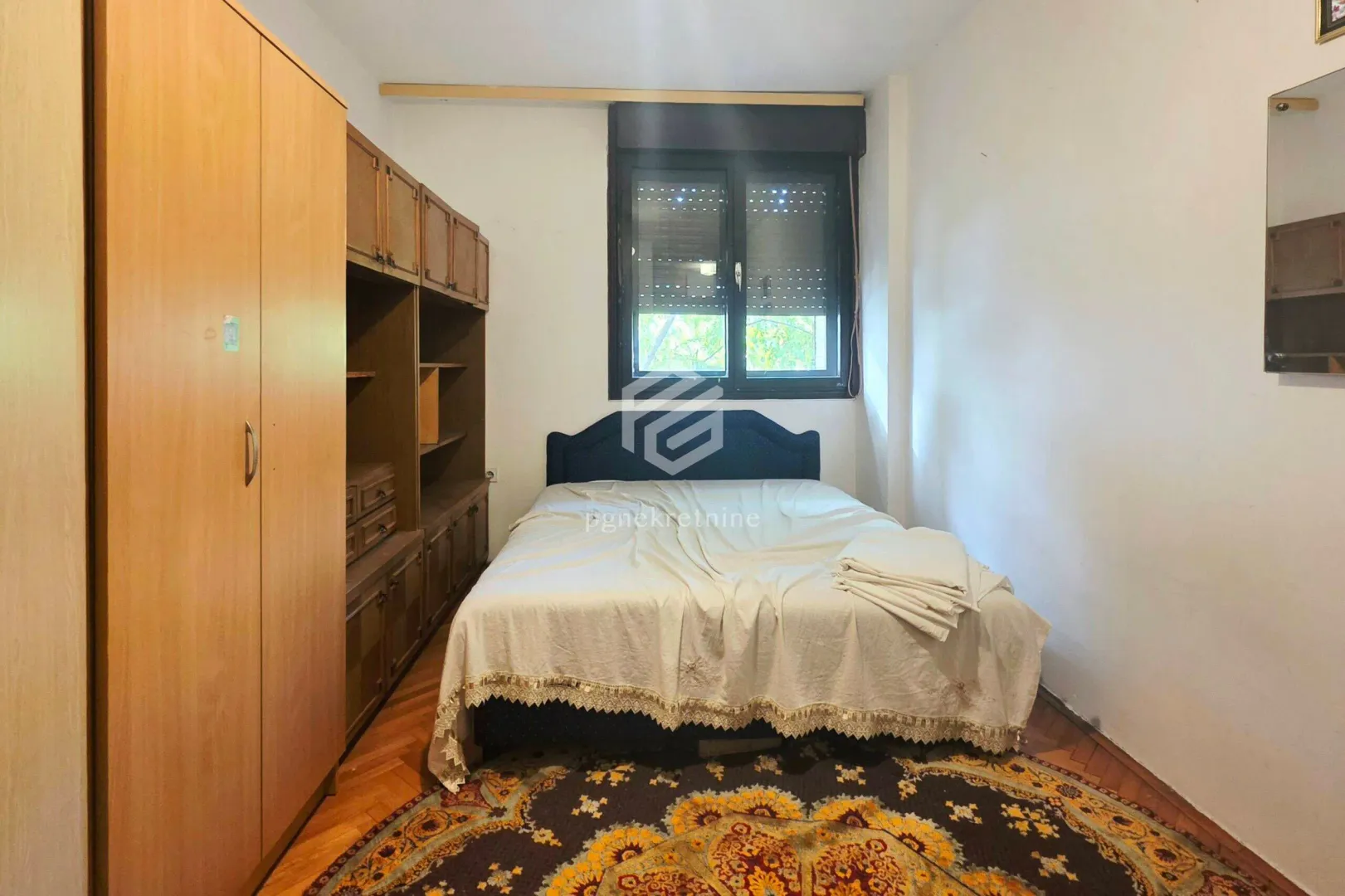 Bedroom with a double bed, wooden wardrobe and a rug.