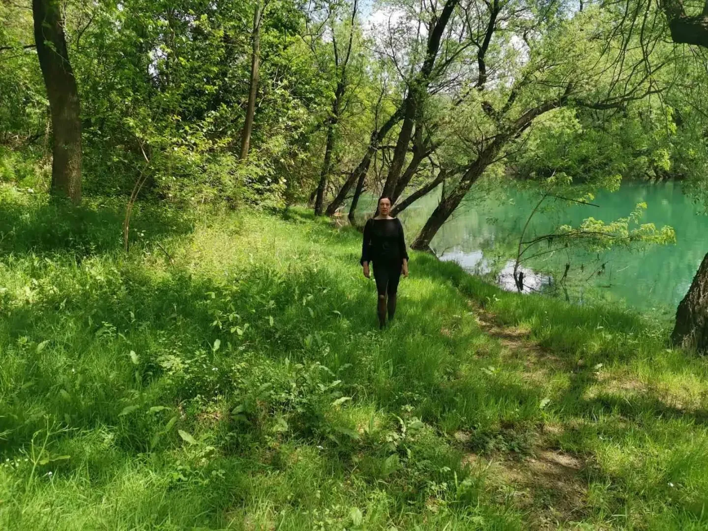 Zemljište pored rijeke okruženo zelenilom i drvećem.