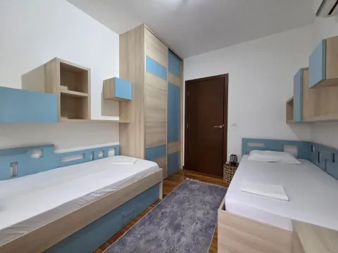 Children's bedroom with two single beds and a fitted wardrobe. - image 9