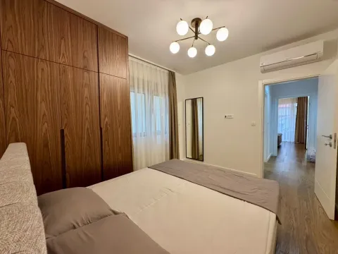 Furnished bedroom with a double bed, large wooden wardrobe, and air conditioning. - image 4