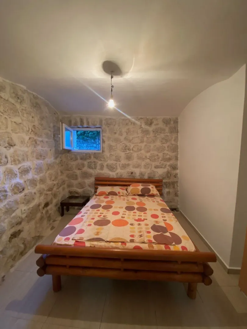 Spavaća soba sa krevetom i zidom od kamena.