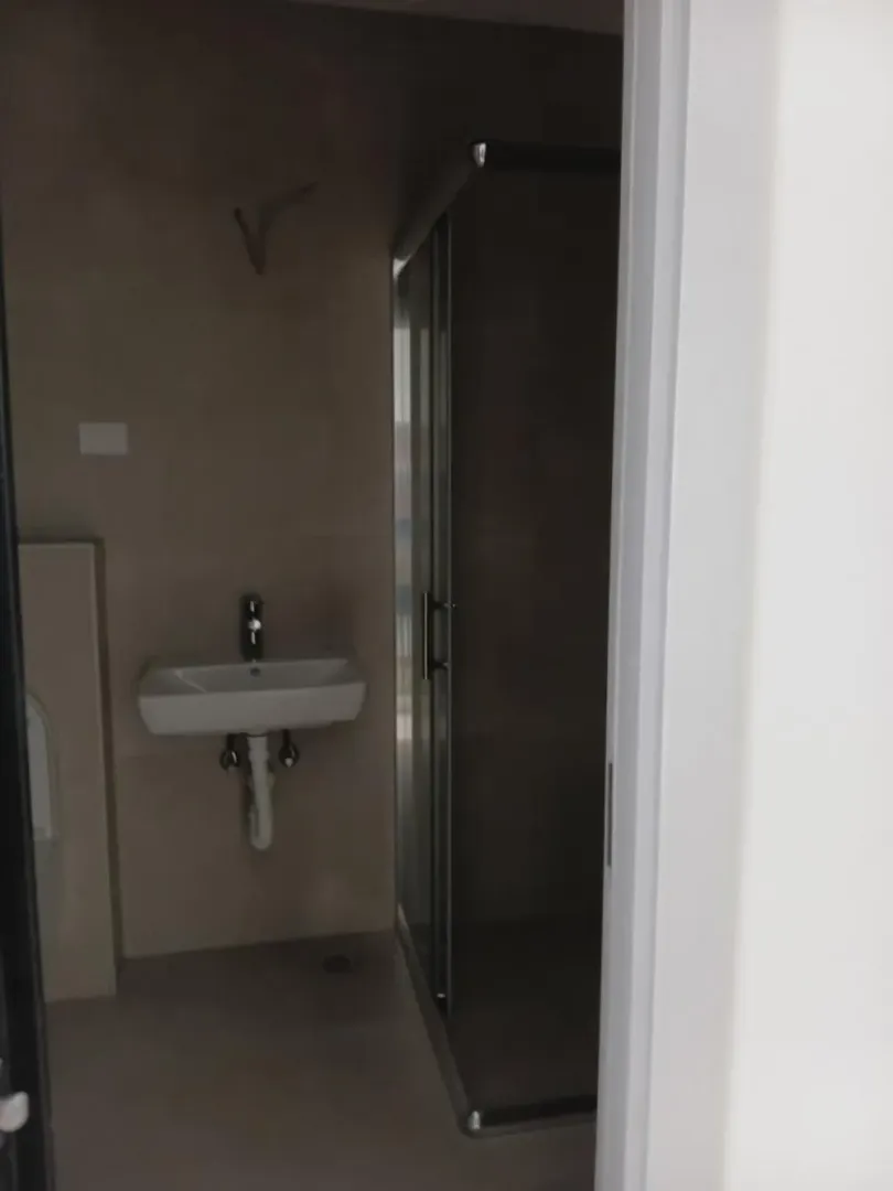 Pogled na kupatilo sa umivaonikom i tuš kabinom.