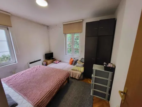 Namještena spavaća soba sa krevetom, ormarom i prozorima. - image 4