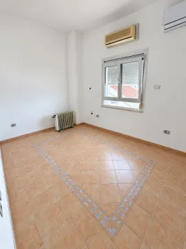 Empty room with ceramic tiles and a radiator. - image 3