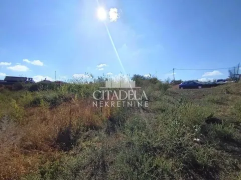 Pogled na neuuređeni plac sa rastinjem i vedrim nebom. - image 2
