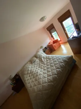 Svijetla spavaća soba sa velikim bračnim krevetom i narandžastom foteljom. - image 32