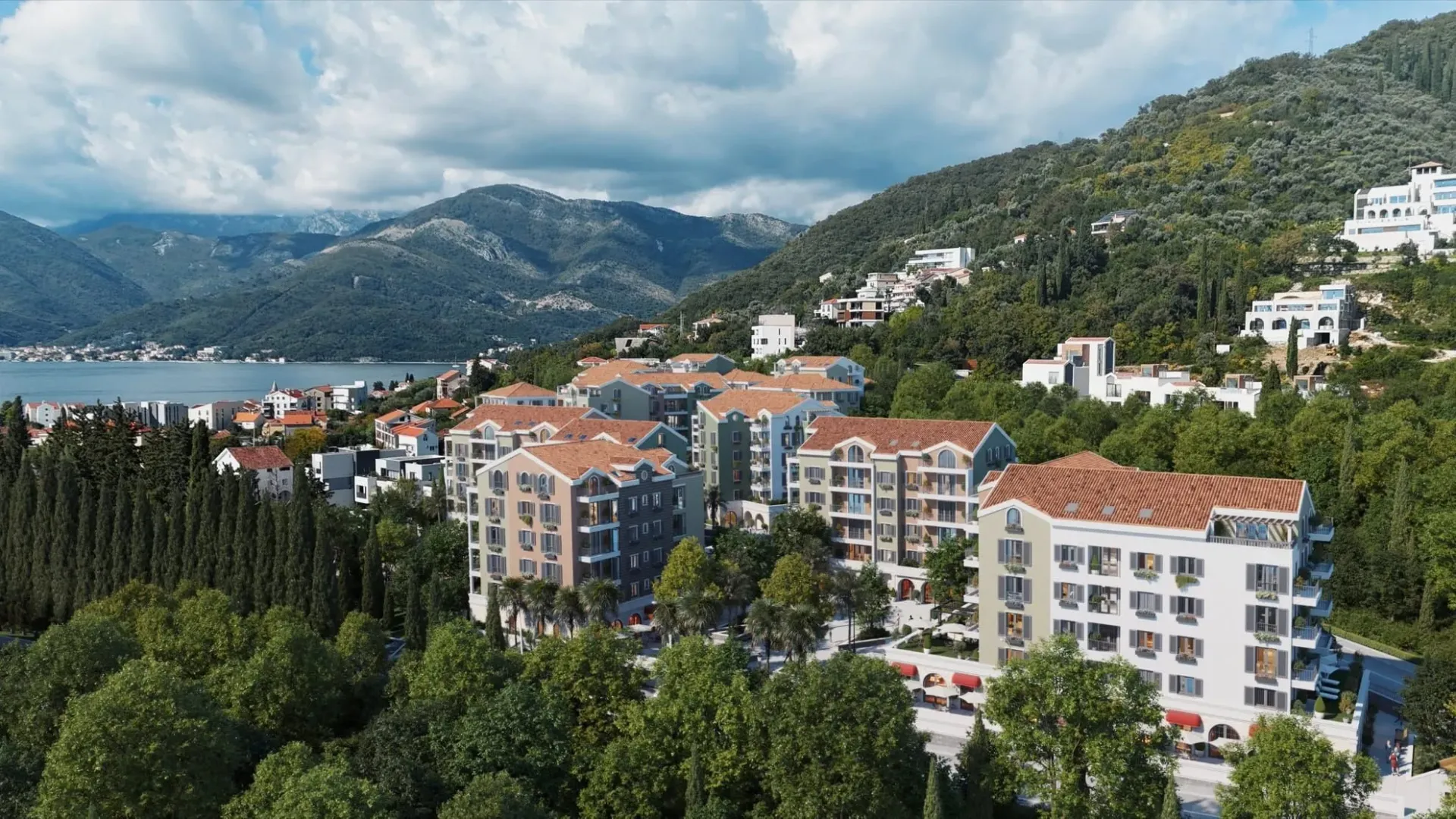 Pogled iz vazduha na stambeni kompleks u blizini mora i planina.