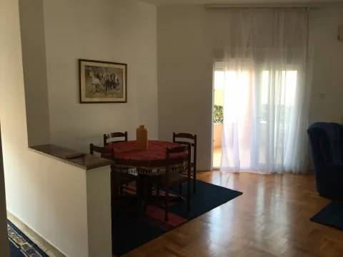 Dining area with a round table and chairs next to a balcony door. - image 6