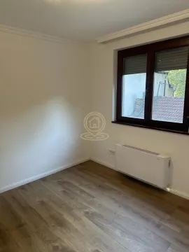 Empty room with wooden flooring, white walls, and a window. - image 9